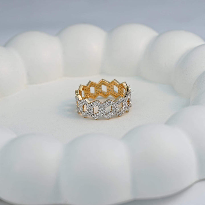 Artistic display of a diamond-studded zigzag gold band on a decorative background.