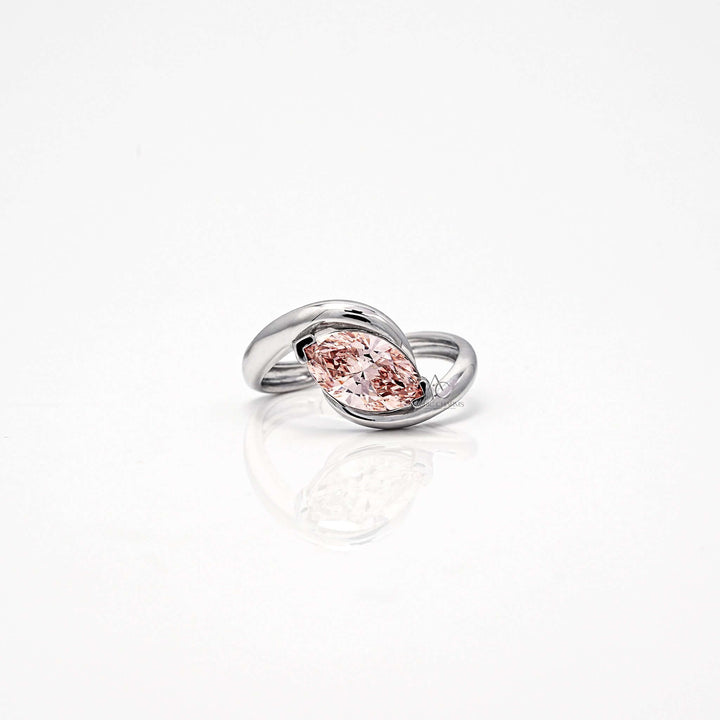 Marquise-cut pink diamond ring with a bypass band in white gold setting.