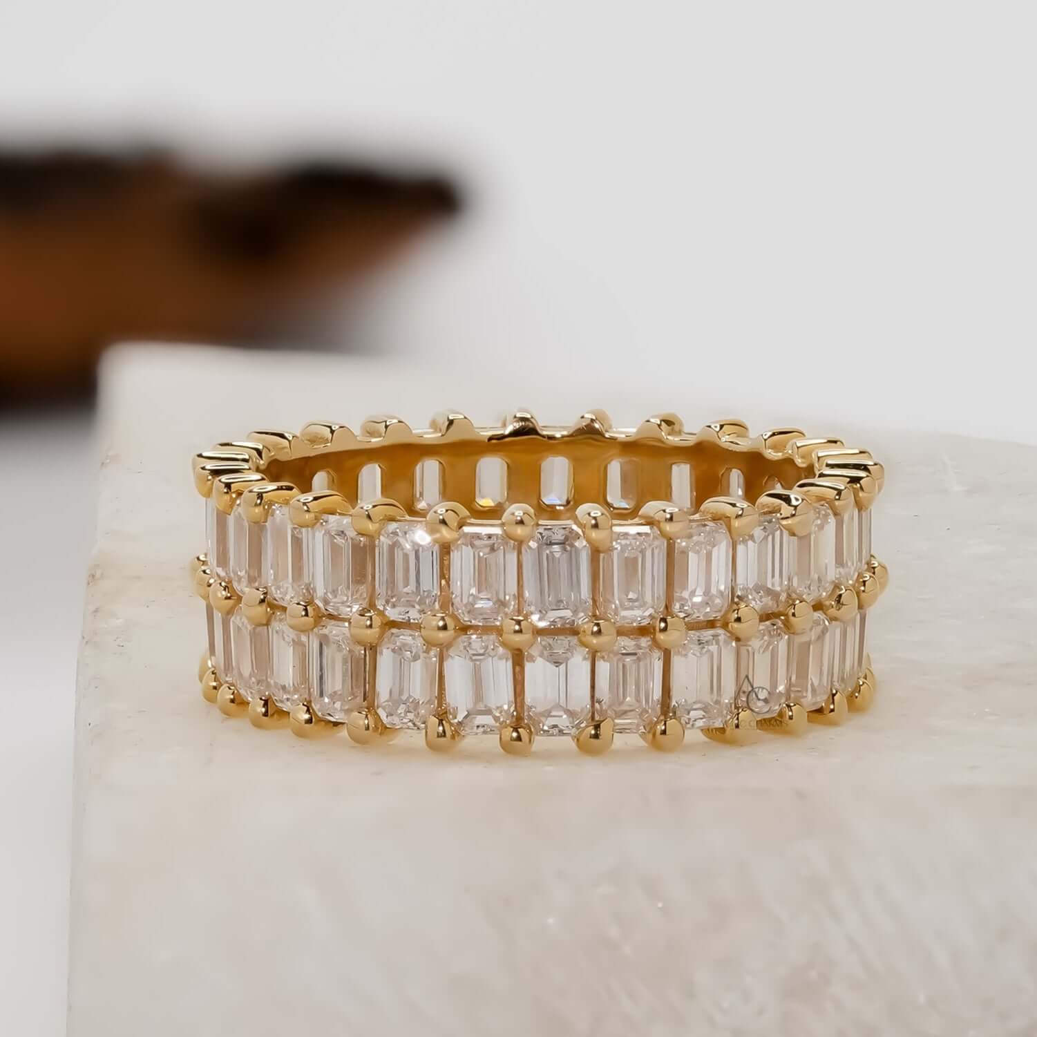 Gold ring with clear diamond on a light background