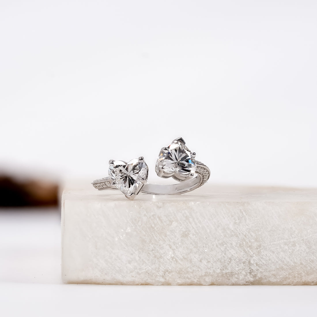 A silver ring featuring two heart-shaped clear gemstones