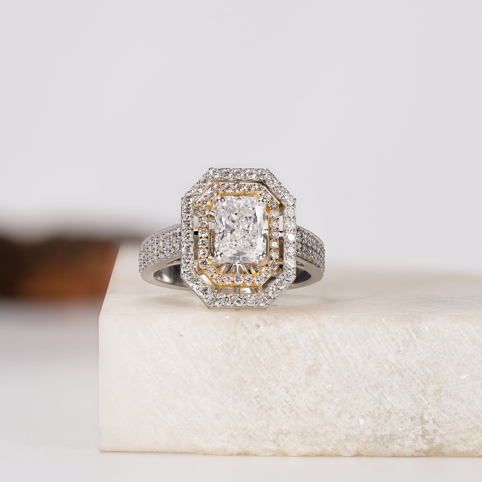 Diamond engagement ring with rectangular center stone and halo setting