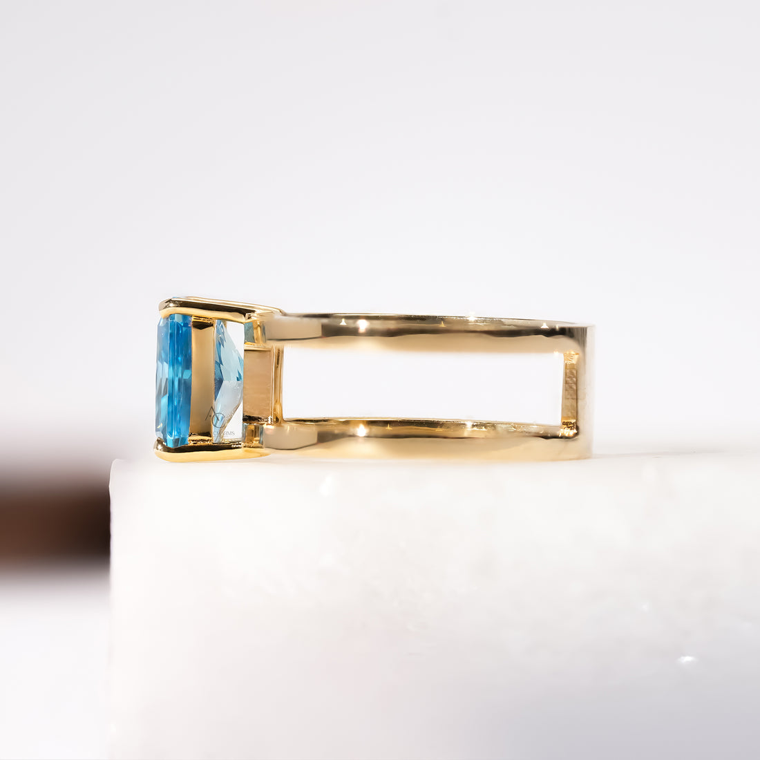 Elegant gold ring showcasing a radiant blue stone in a four-prong setting.