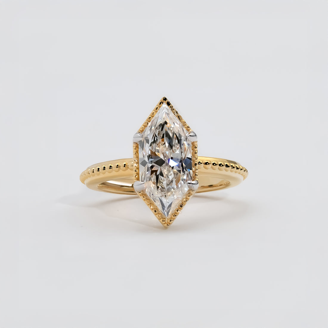 Yellow gold ring featuring a marquise-cut diamond with a milgrain bezel setting.