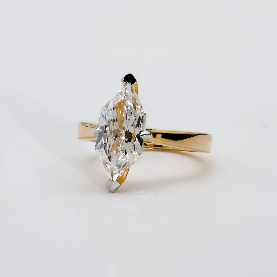 A classic marquise diamond solitaire ring set in yellow gold with a sleek, polished band.
