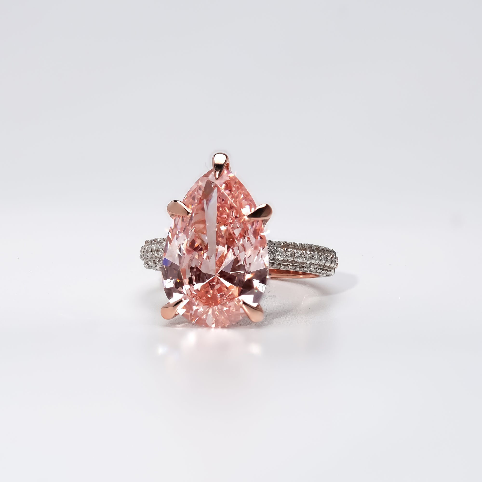 A rose gold engagement ring featuring a large pear-shaped pink gemstone at the center, held by six prongs. The band is encrusted with small round white diamonds, adding shimmer and elegance to the romantic design.
