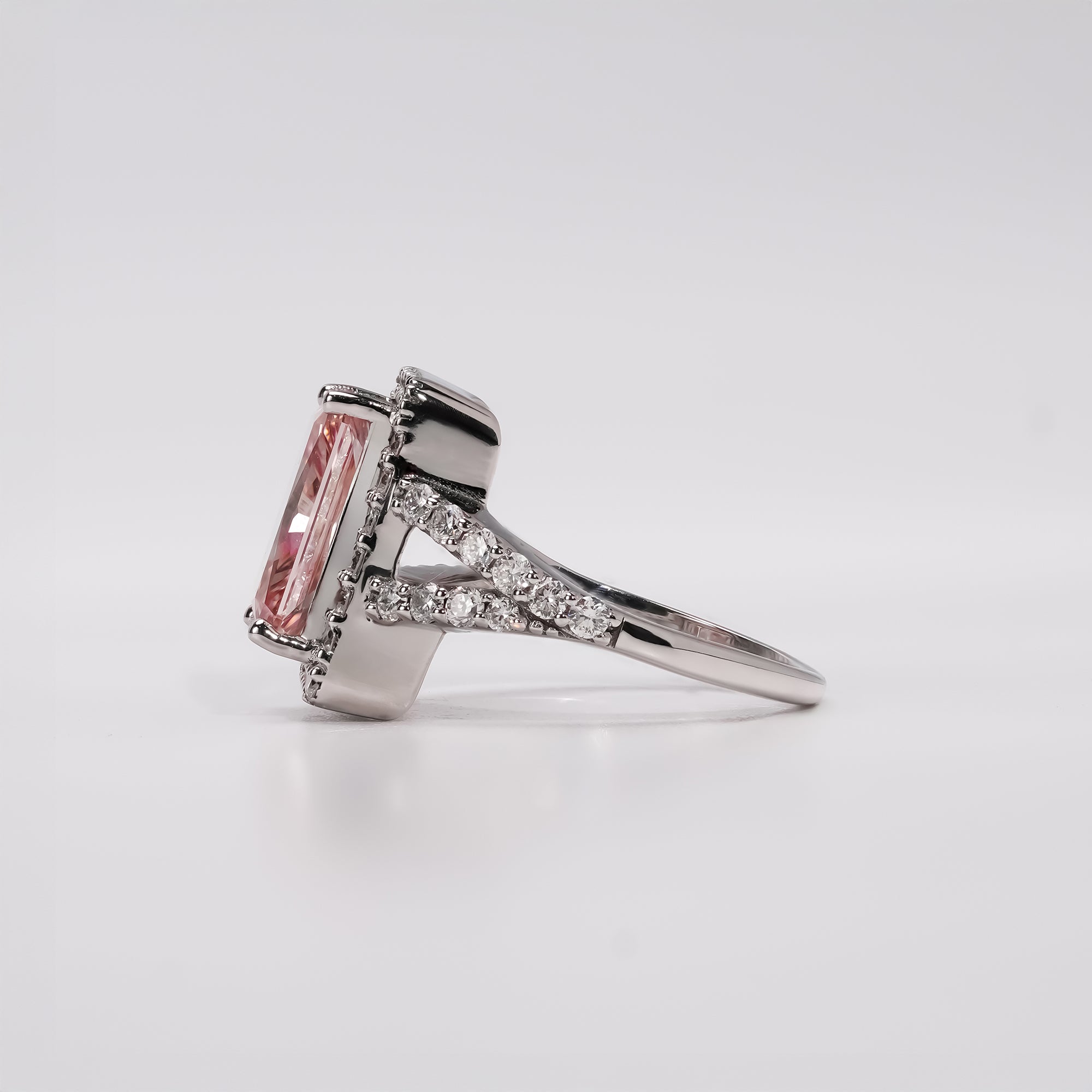 Pink diamond halo ring with white gold split band and pavé diamonds.
