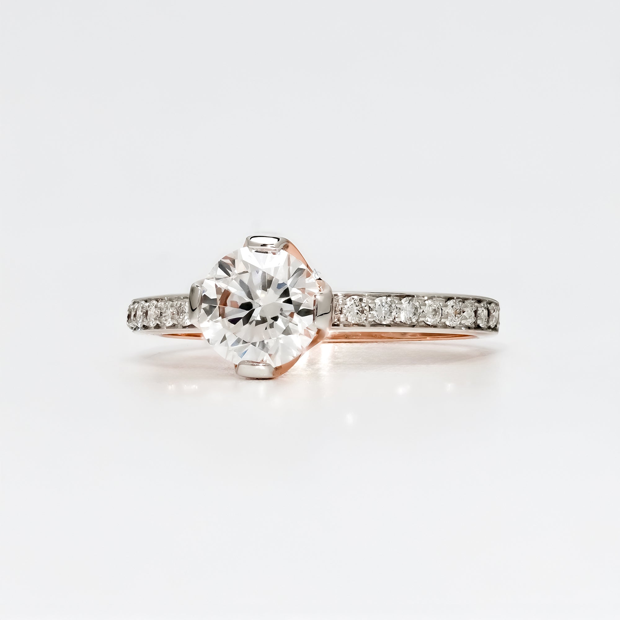 A round brilliant-cut diamond engagement ring with a pavé diamond band in a polished rose gold setting.