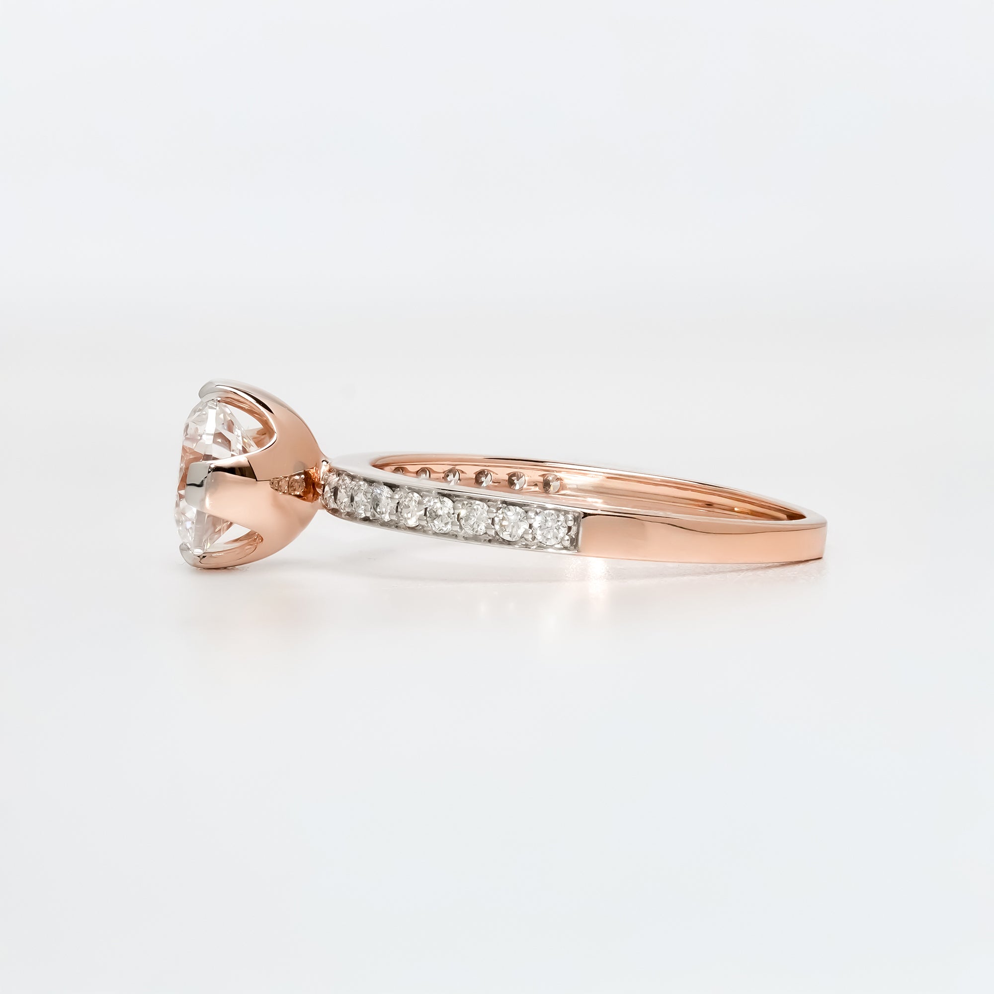 Classic solitaire engagement ring featuring a sparkling round diamond centerpiece on a pavé diamond band.