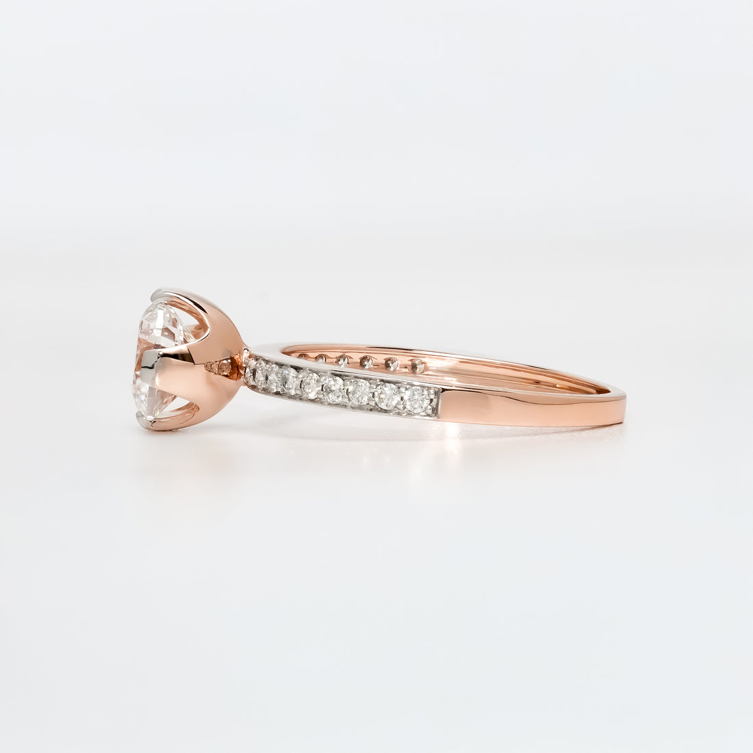 Classic solitaire engagement ring featuring a sparkling round diamond centerpiece on a pavé diamond band.