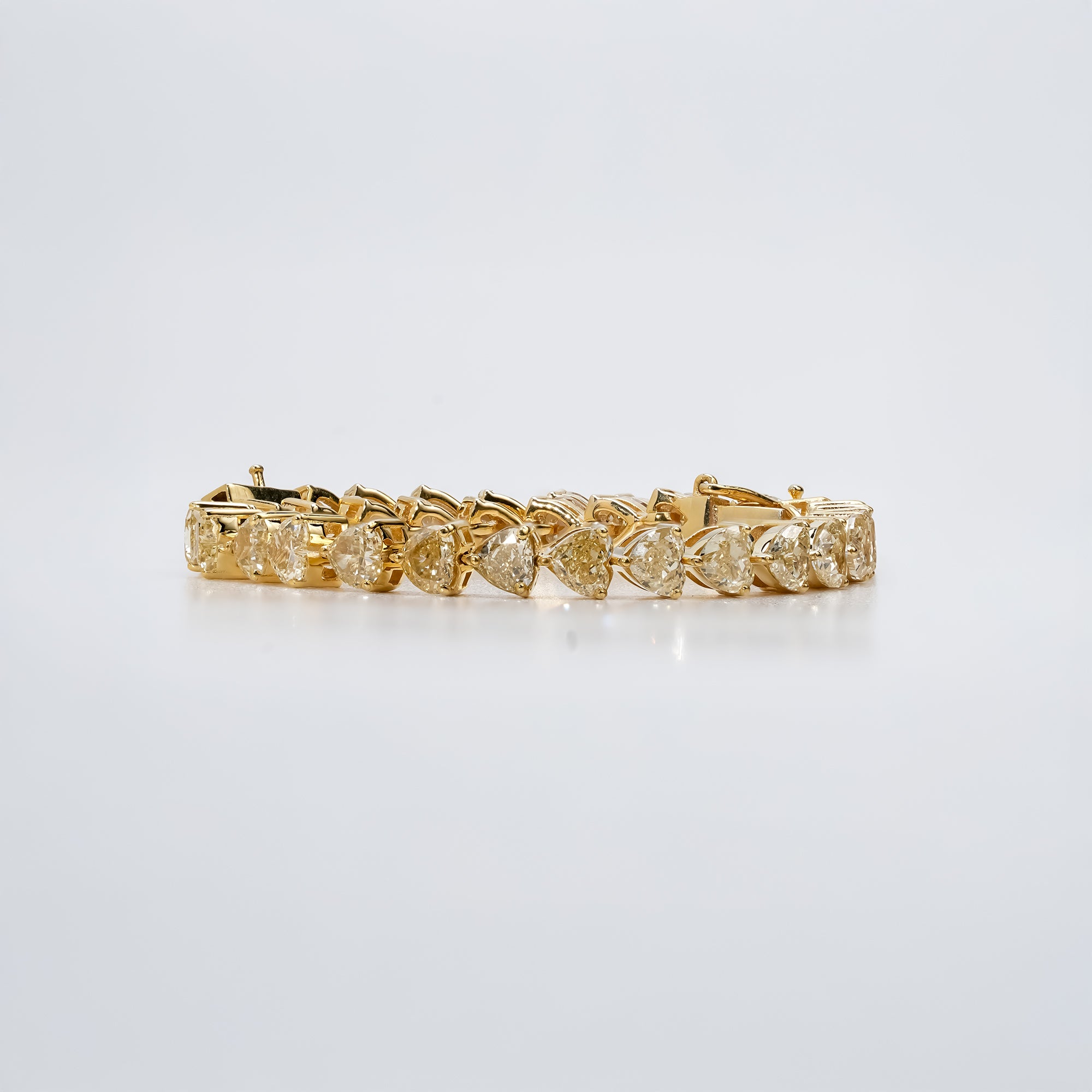 Yellow gold tennis bracelet with heart -shaped diamonds, designed in a continuous prong setting for a refined and classic look.