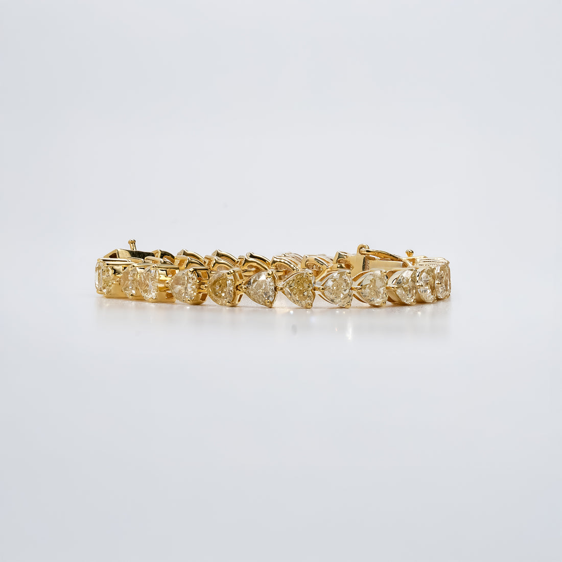 Yellow gold tennis bracelet with heart -shaped diamonds, designed in a continuous prong setting for a refined and classic look.