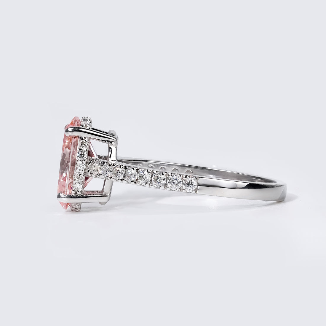 Oval-cut pink diamond engagement ring surrounded by shimmering white diamonds on a sleek white gold band.