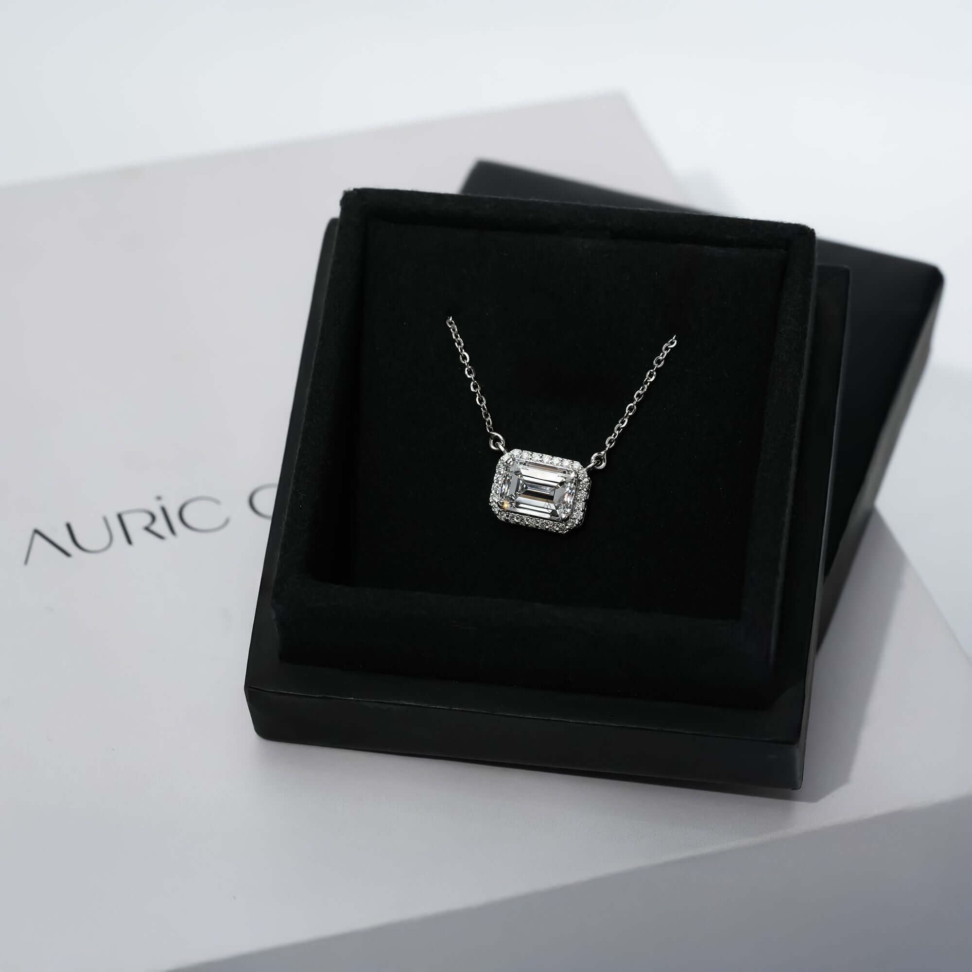 A delicate silver necklace featuring a halo-style diamond pendant, beautifully resting on the neckline for a timeless and graceful look.