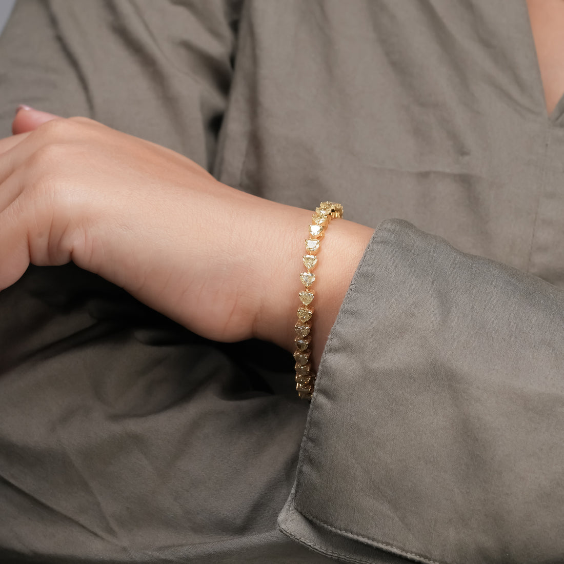 An exquisite yellow gold bracelet with perfectly matched heart-cut diamonds, showcasing a flawless blend of brilliance, balance, and refined luxury.