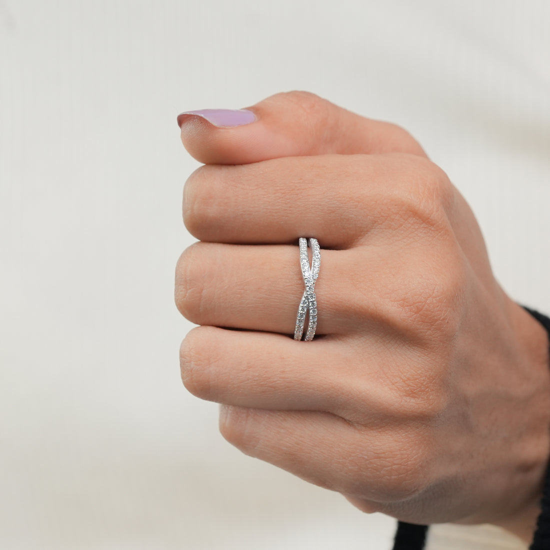 Luxury silver diamond ring featuring infinity twist design.