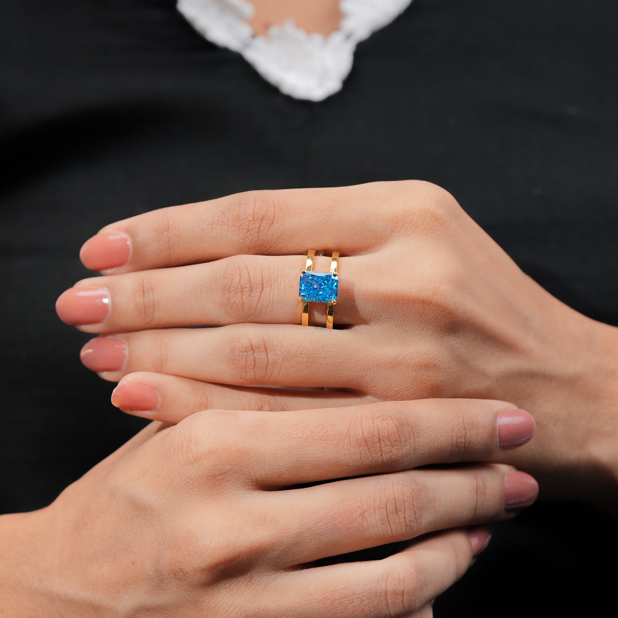 Luxury gold ring featuring a radiant-cut blue diamond-like gemstone.