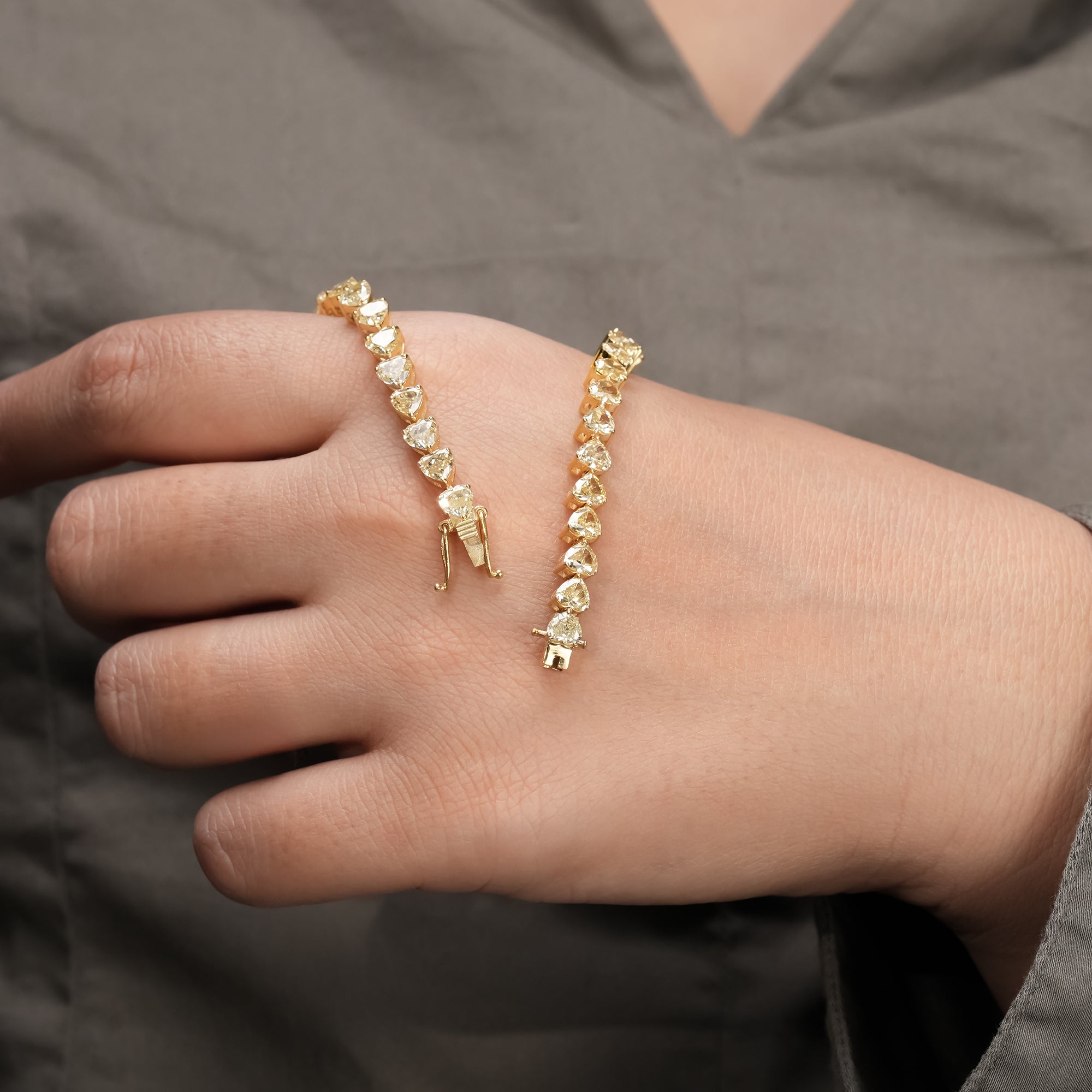 Polished yellow gold bracelet with a line of heart-cut diamonds for a sleek and sophisticated style.