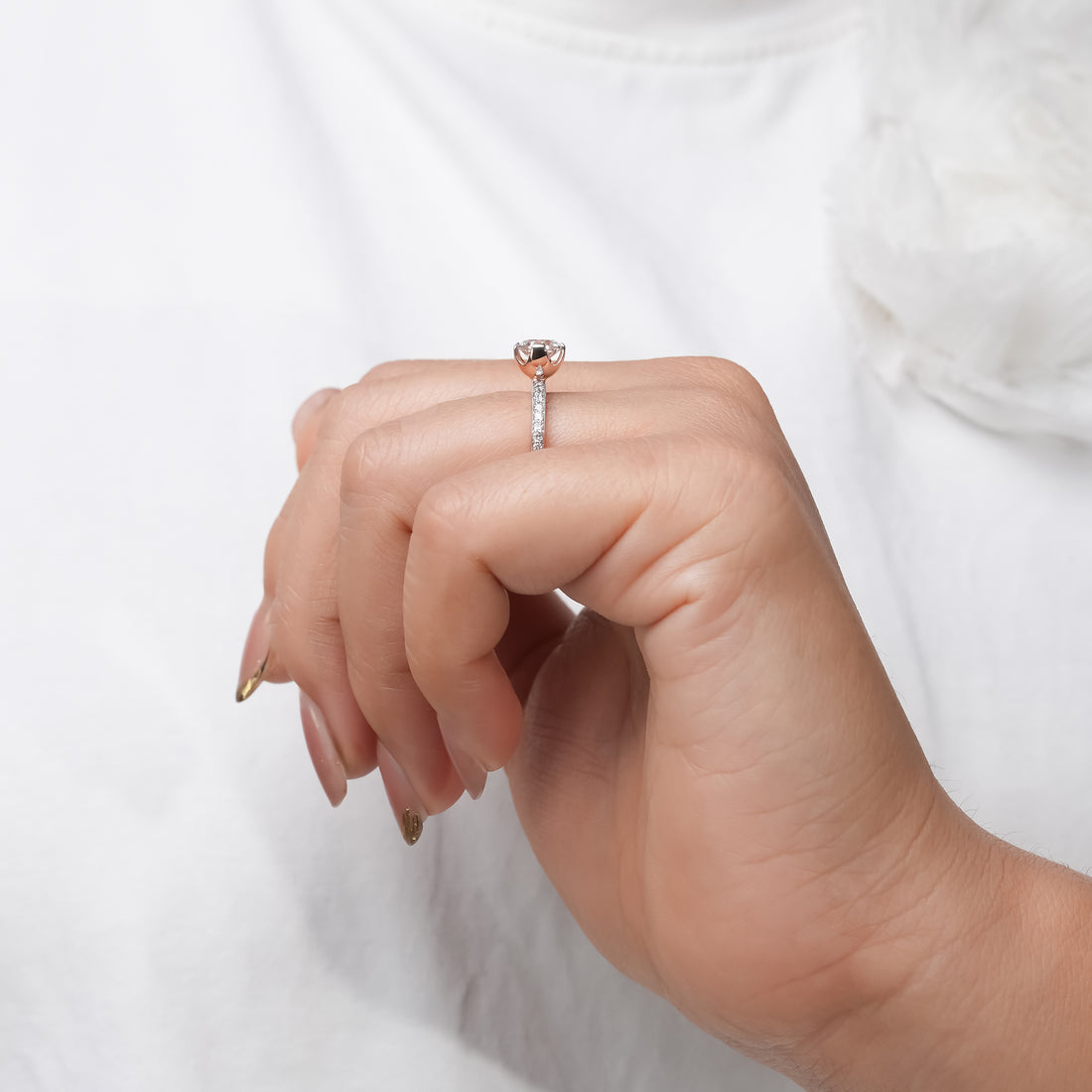 Round diamond engagement ring in white gold with pavé band, classic solitaire style.