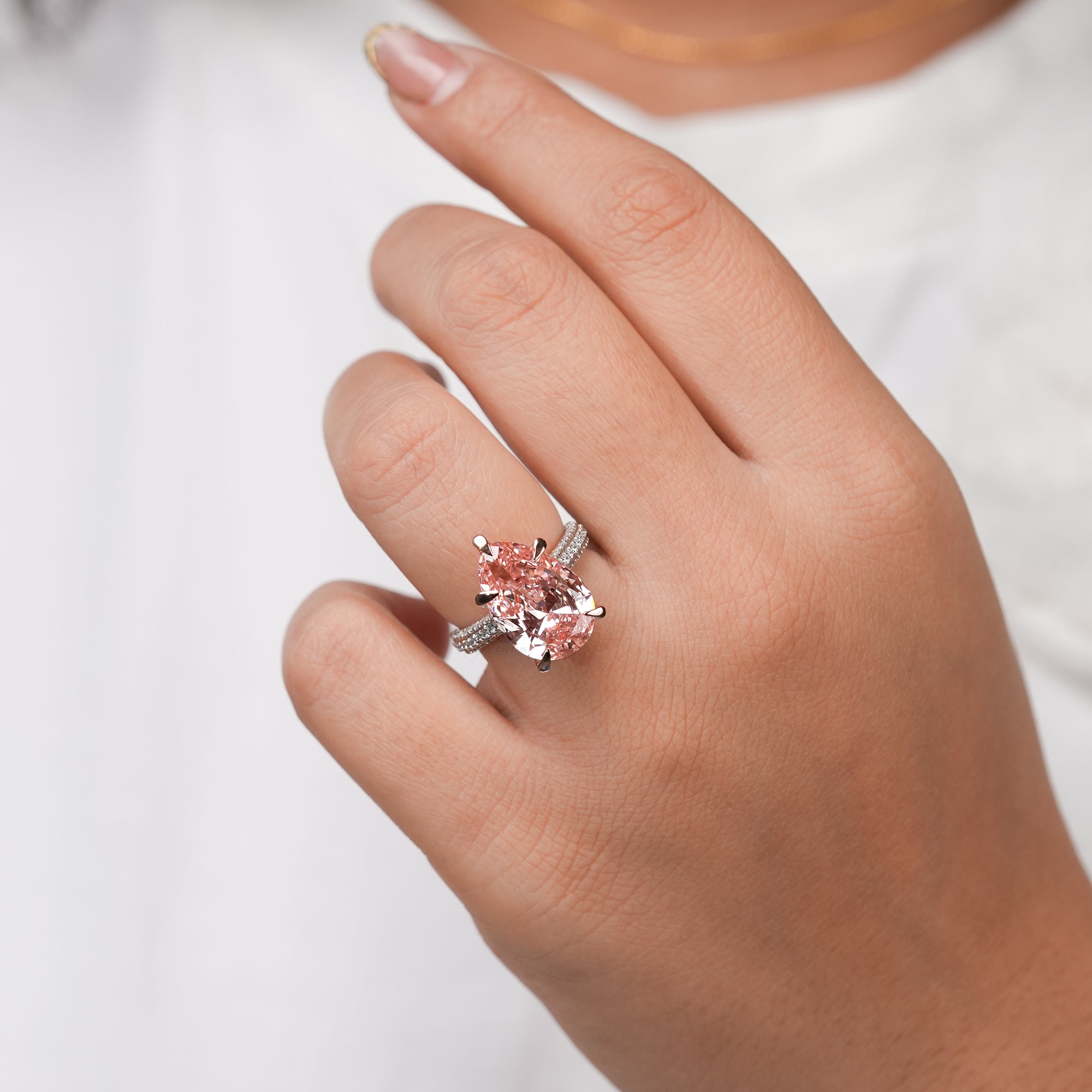 Rose gold engagement ring with pear-cut pink gemstone and pavé diamond band, featuring a luxurious and feminine design ideal for special occasions.