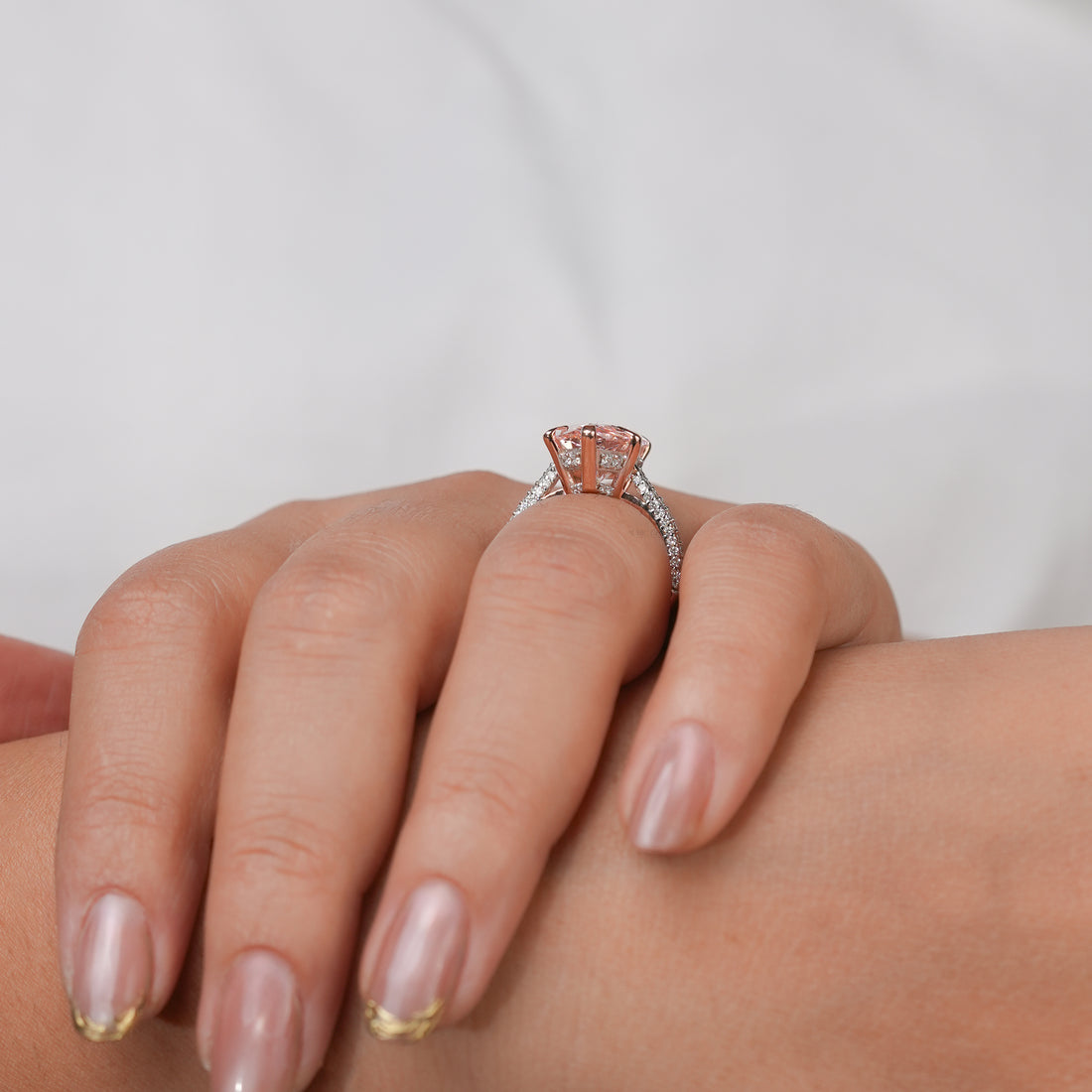 Rose gold ring with a pear-shaped pink gemstone and a diamond-accented band.