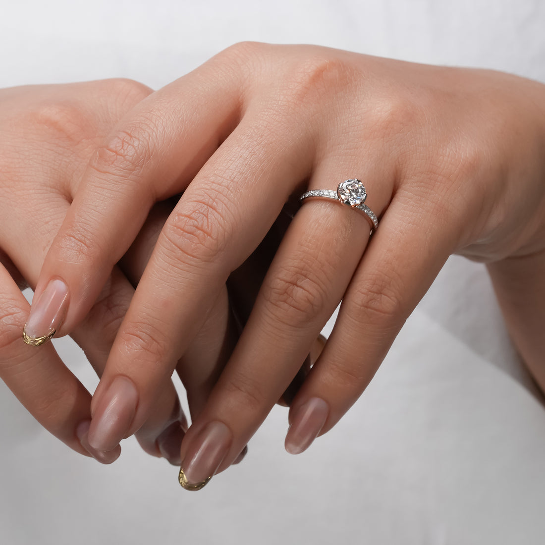 Modern classic engagement ring with a round-cut diamond and sparkling pavé accents for timeless sparkle.
