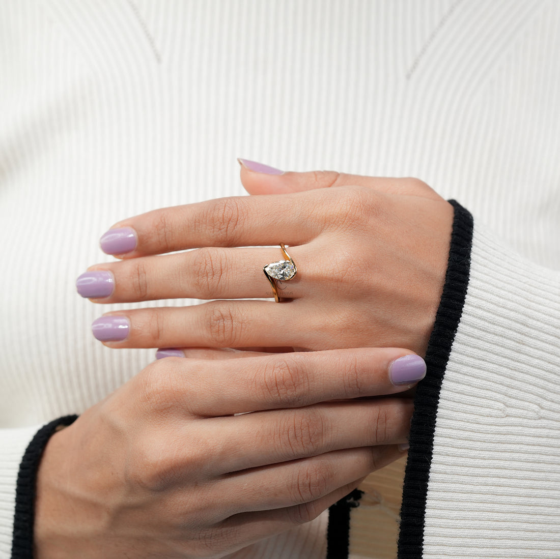 gold engagement ring featuring a pear-shaped diamond in an open
