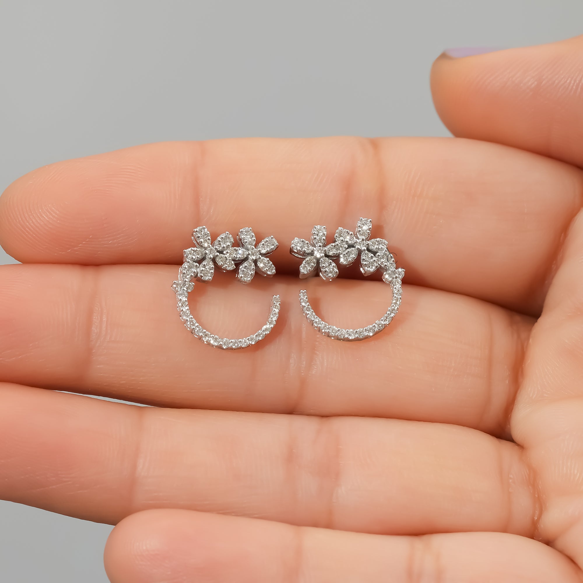 Delicate Rosalie floral lab-grown diamond hoop earrings shown in hand, embodying sustainable luxury and elegant grace.