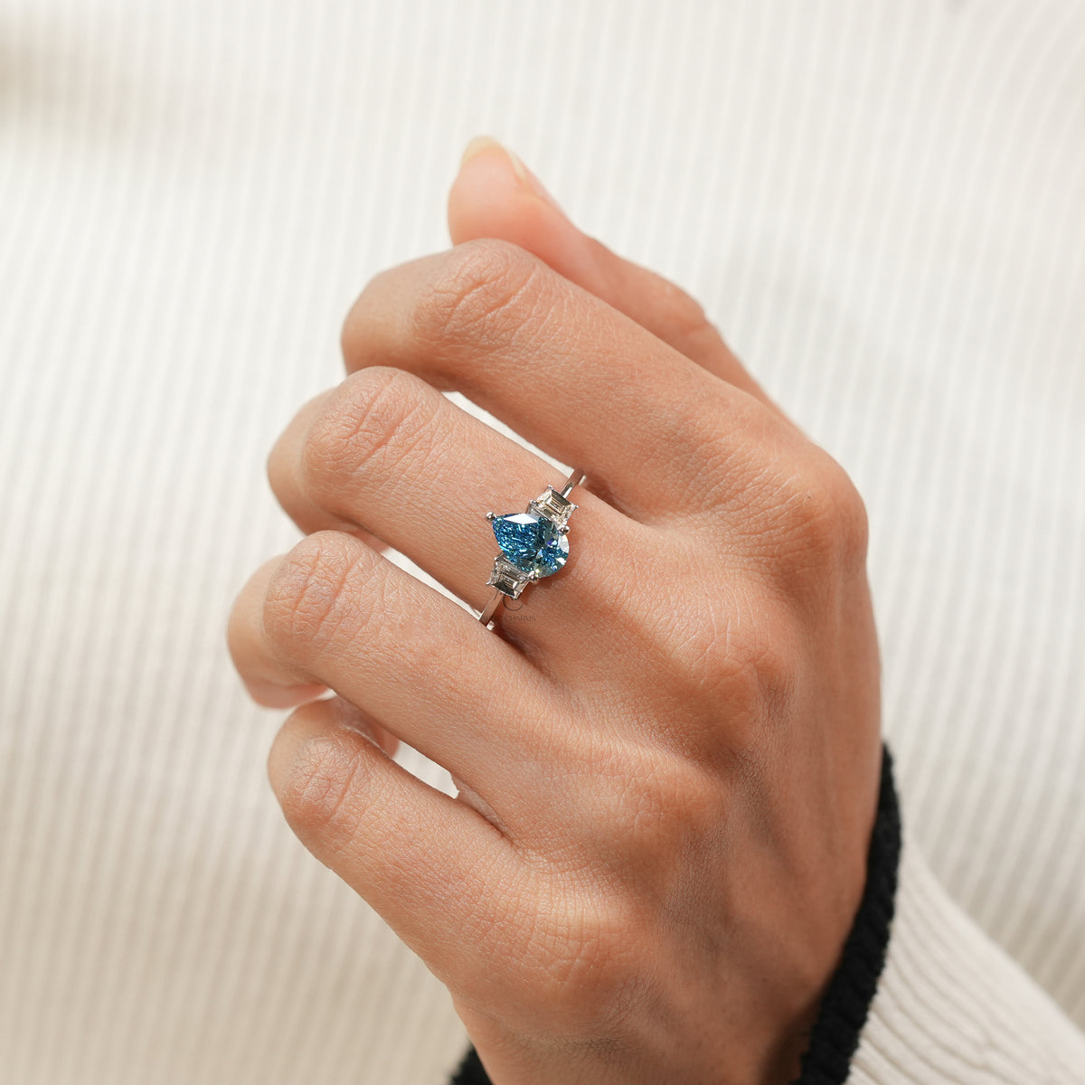 Center Stone: Fancy Vivid Blue Pear Cut, Ct Side Stones