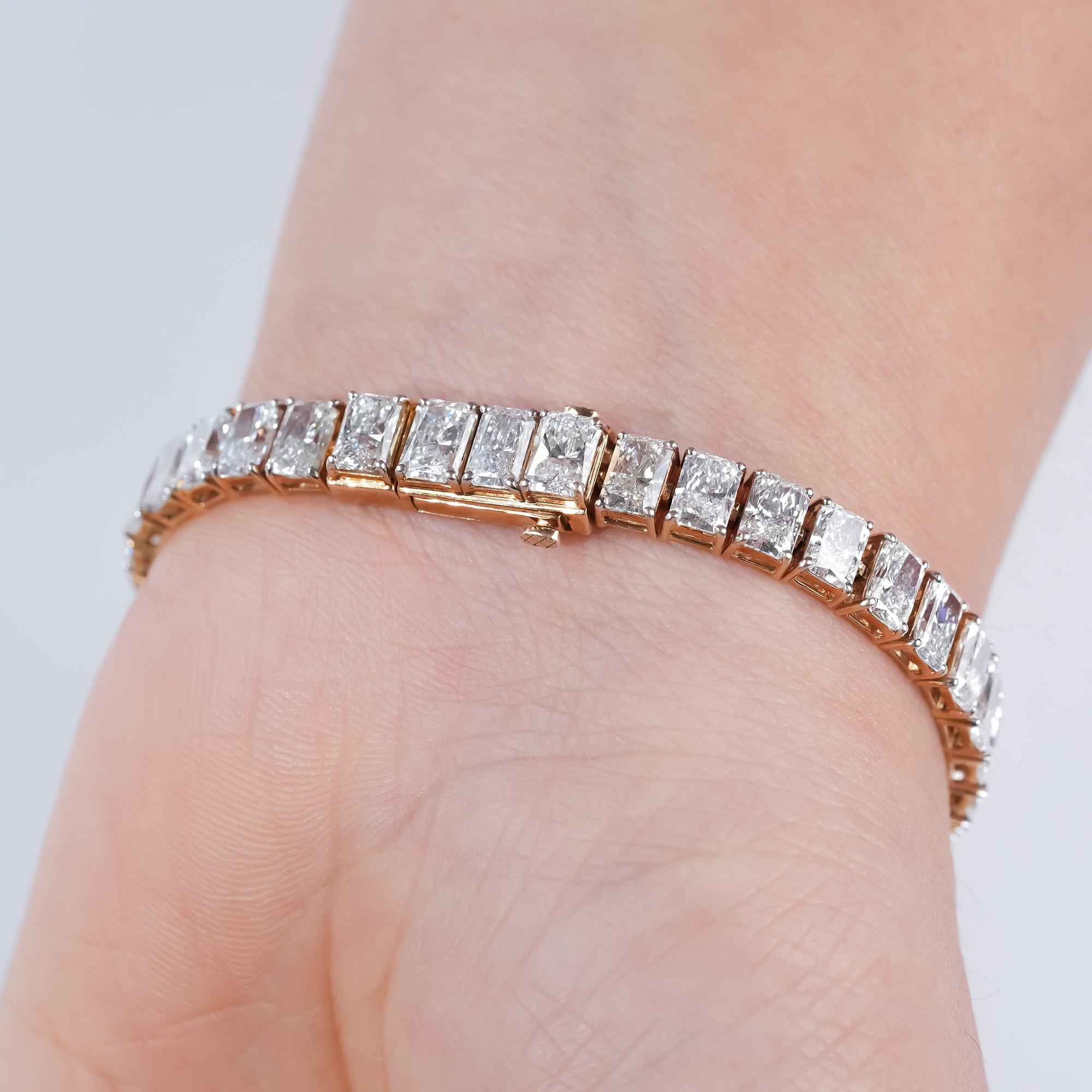 Gold diamond bracelet with radiant-cut stones in a channel setting, perfect for elegant evening wear or luxury gifting.