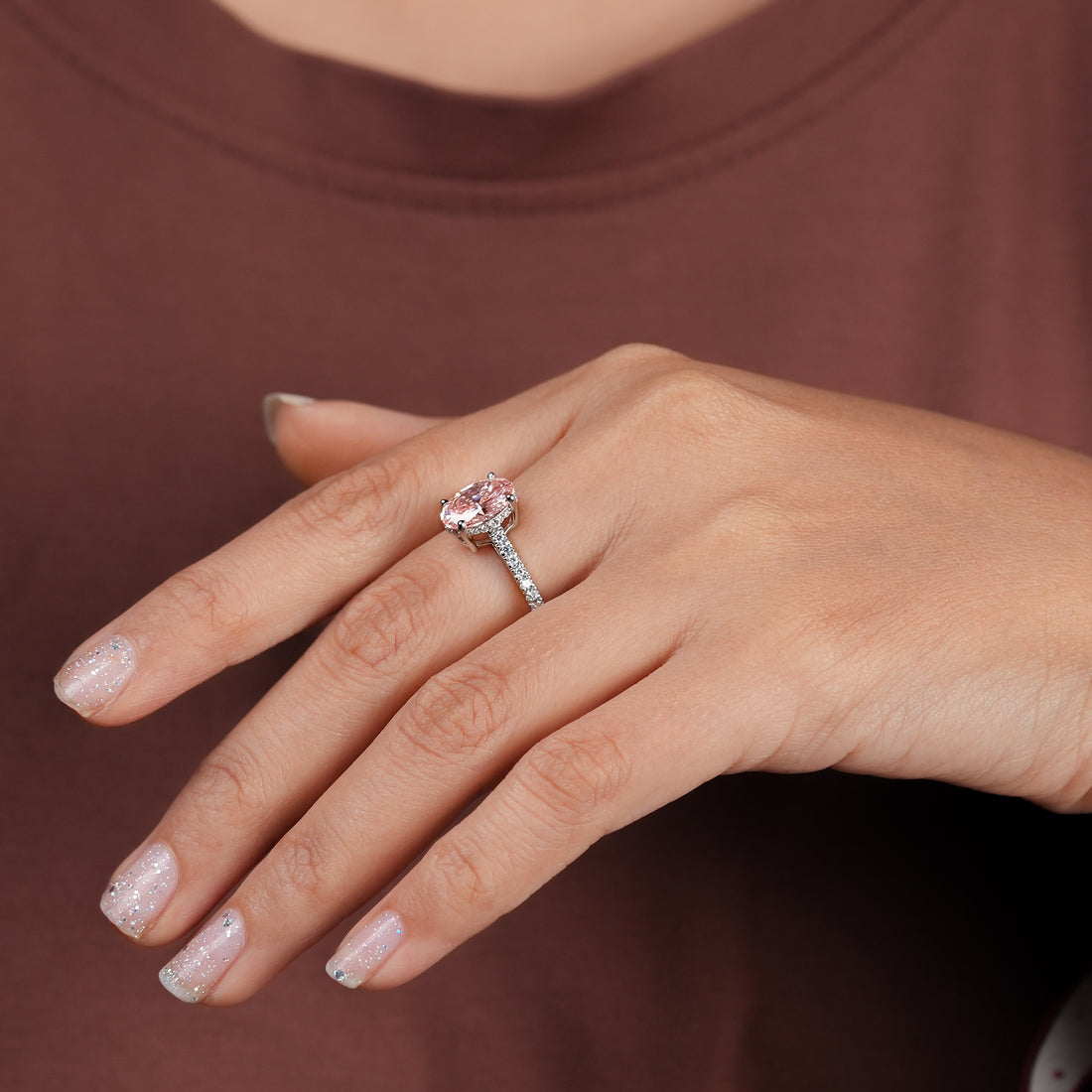 Oval pink diamond engagement ring in white gold with pavé diamond band, elegant and timeless design.