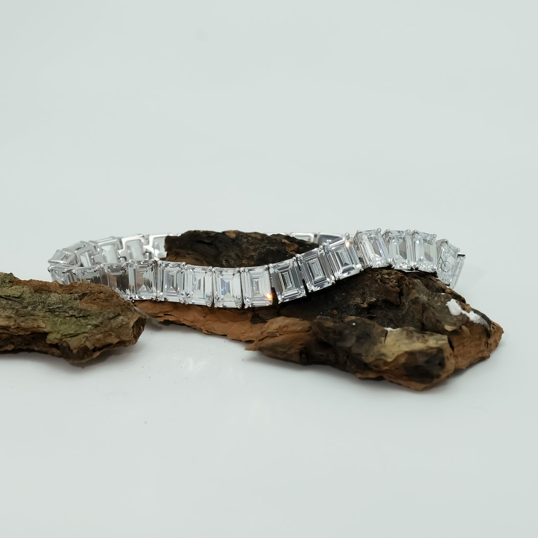 A dazzling white gold diamond bracelet graces the wrist, blending modern geometry