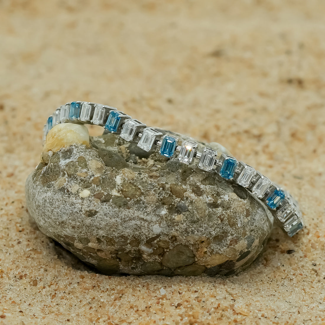 Silver bracelet with alternating blue topaz and white emerald-cut stones