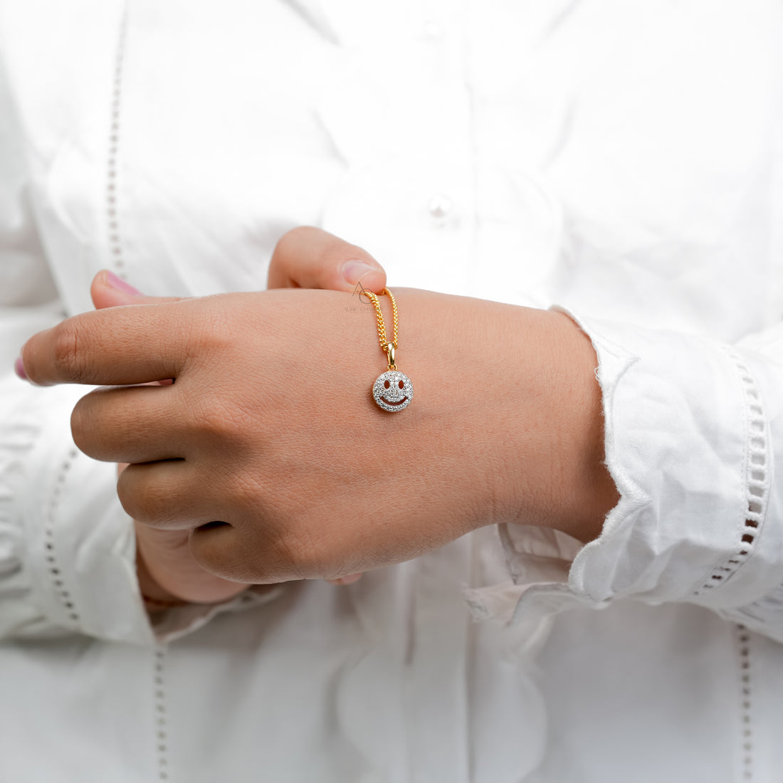 A refined two-tone wristwatch paired with a gold chain and a sparkling smiley pendant, creating a joyful balance of luxury and personality.