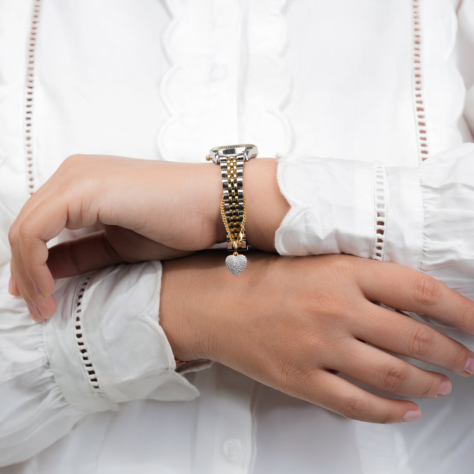 A stylish two-tone bracelet watch featuring a gold chain with a sparkling heart pendant, symbolizing timeless love and sophistication.