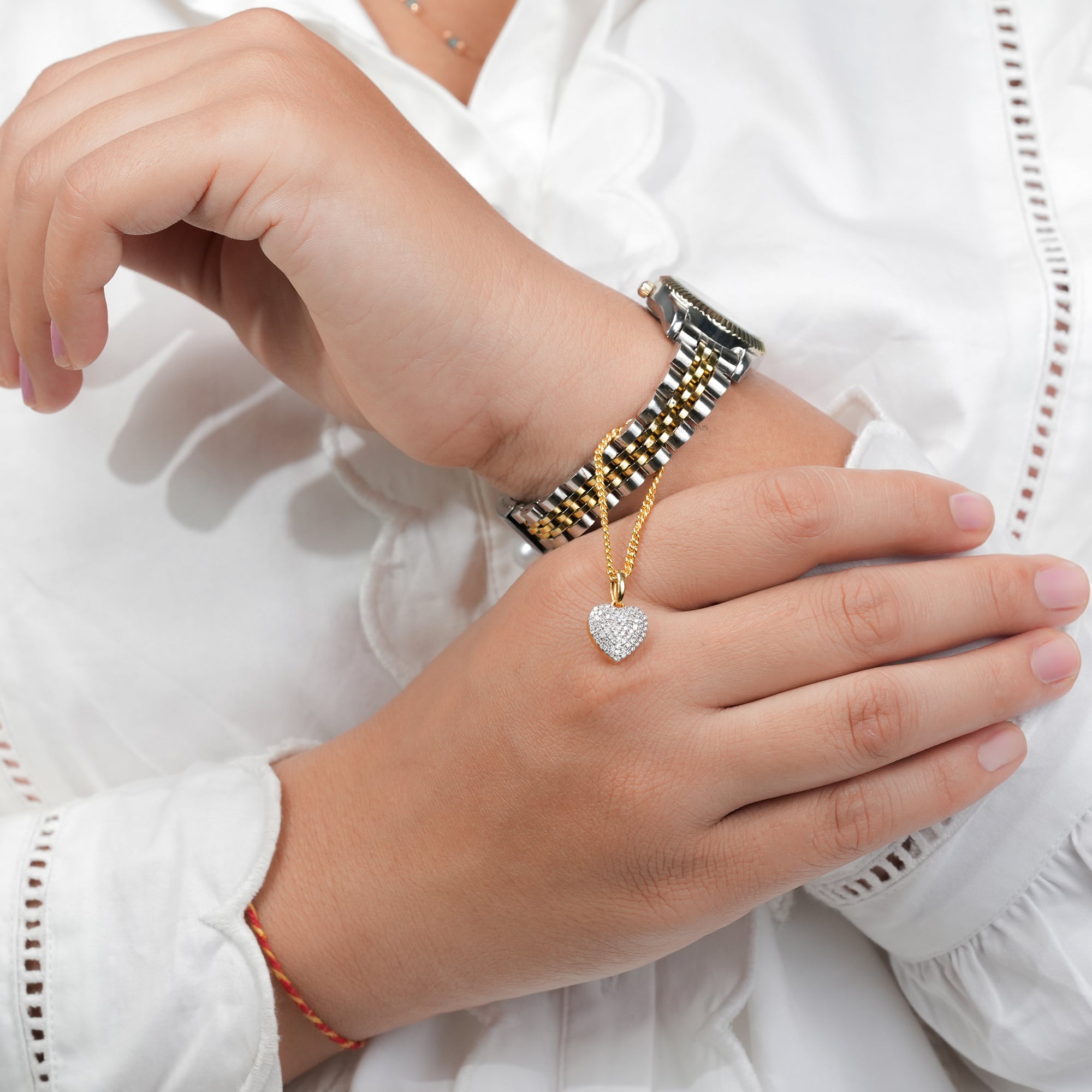 A refined two-tone wristwatch enhanced with a diamond-studded heart charm in gold, showcasing exquisite craftsmanship and elegant detail.