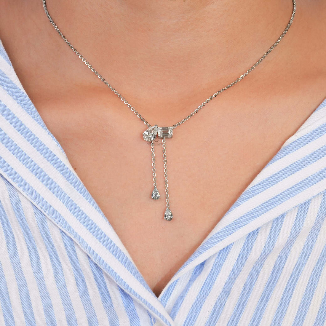 Elegant lab-grown diamond Toi et Moi pendant necklace worn on neck, featuring emerald and pear cut diamonds for a luxurious touch.