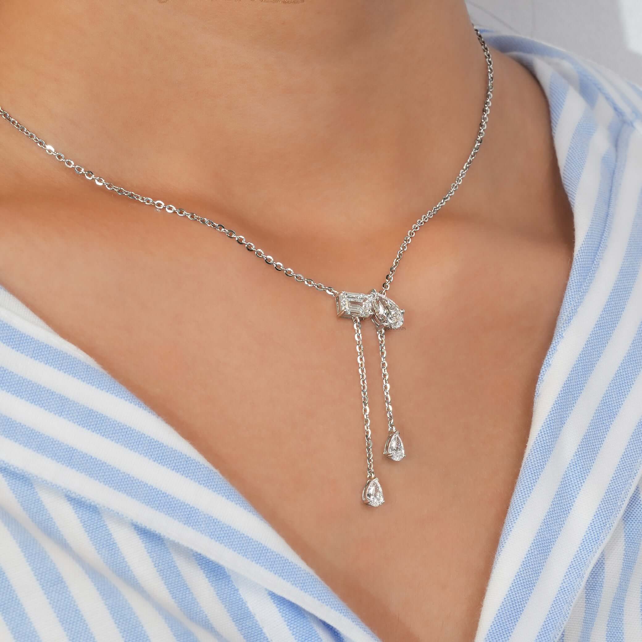 Elegant Lab Grown Diamond Toi et Moi pendant necklace worn on neck, featuring Emerald and Pear Cuts with dangling chains.