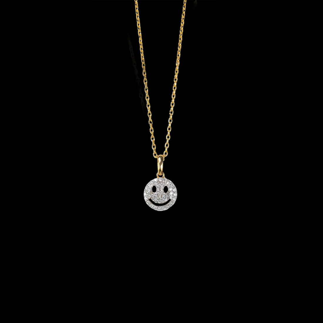 A gold necklace with a sparkling smiley face pendant, combining luxury and joy in a stylish, diamond-studded design.