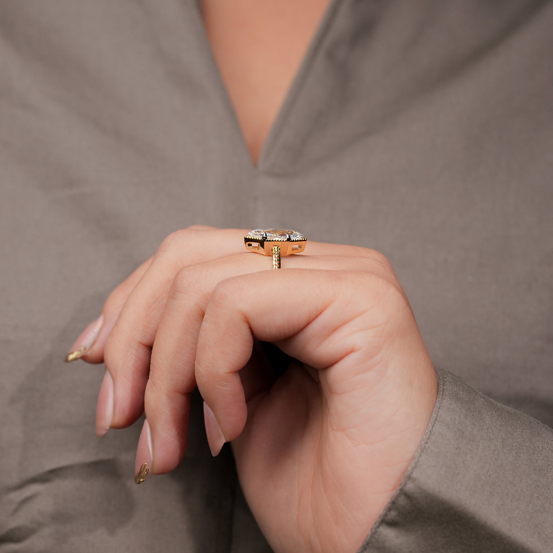 Marquise-cut diamond engagement ring set in yellow gold with intricate milgrain accents.