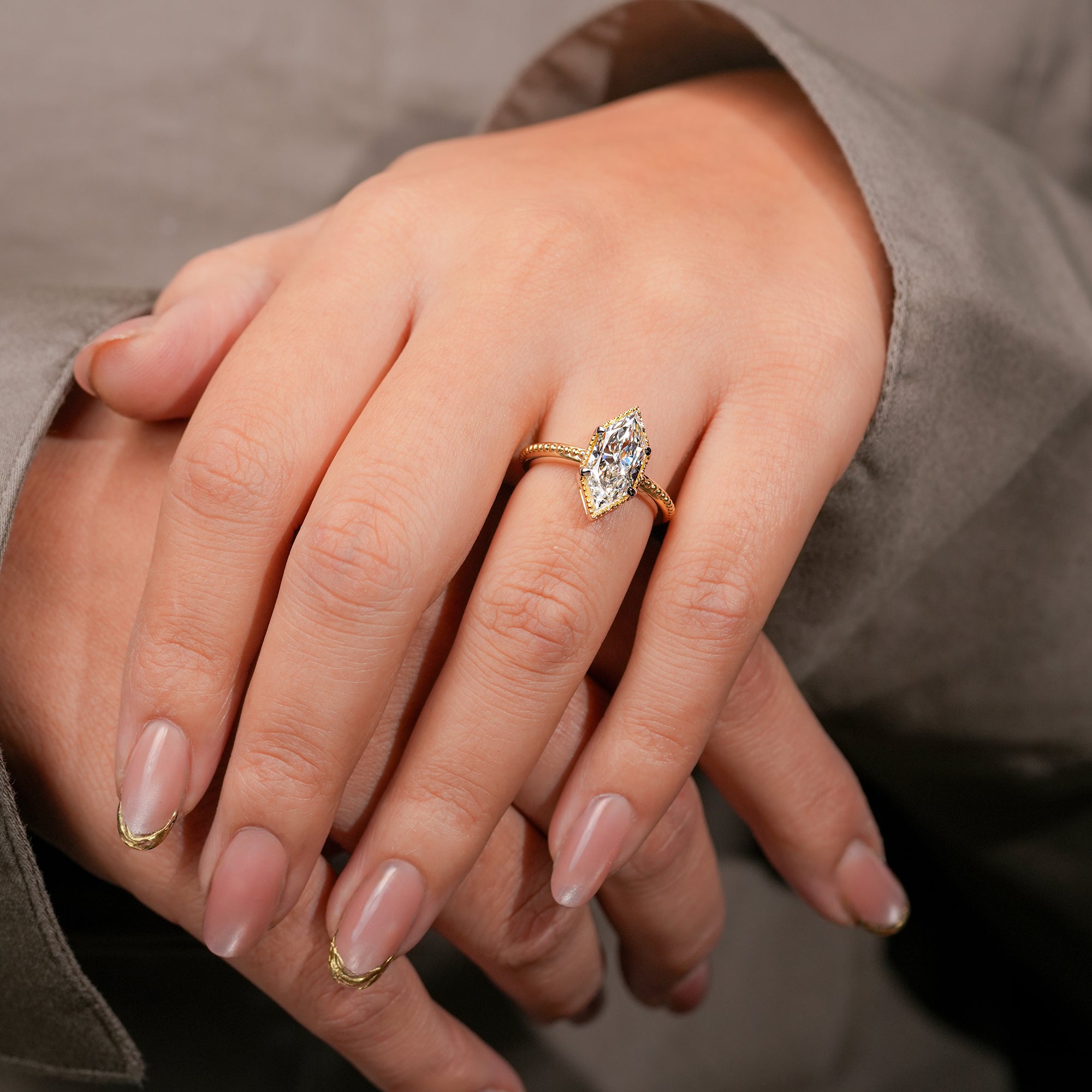 Vintage-inspired marquise-cut diamond ring in polished yellow gold band.