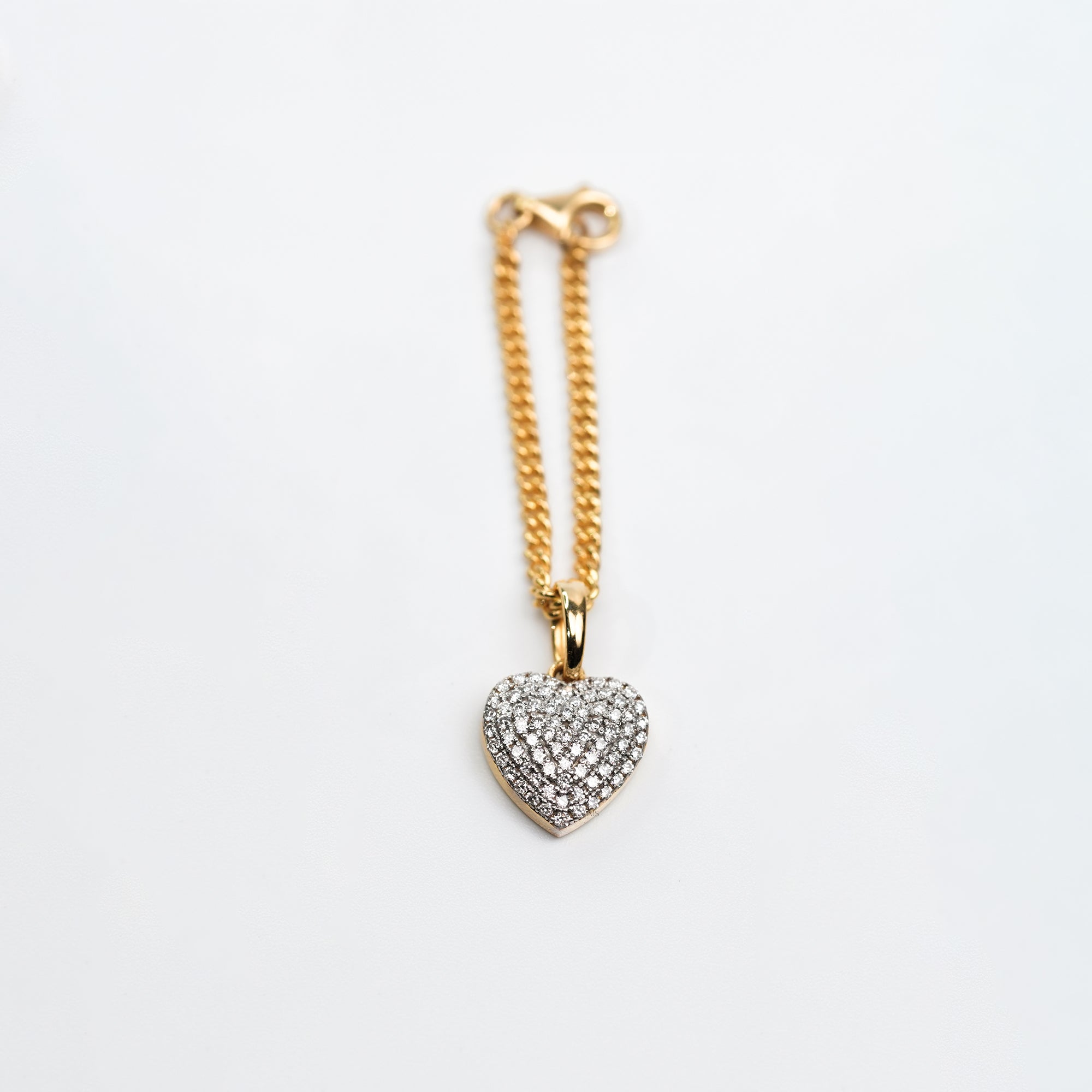 A sophisticated two-tone metal bracelet watch styled with a gold chain and a heart-shaped diamond charm, offering a chic blend of luxury and romance.