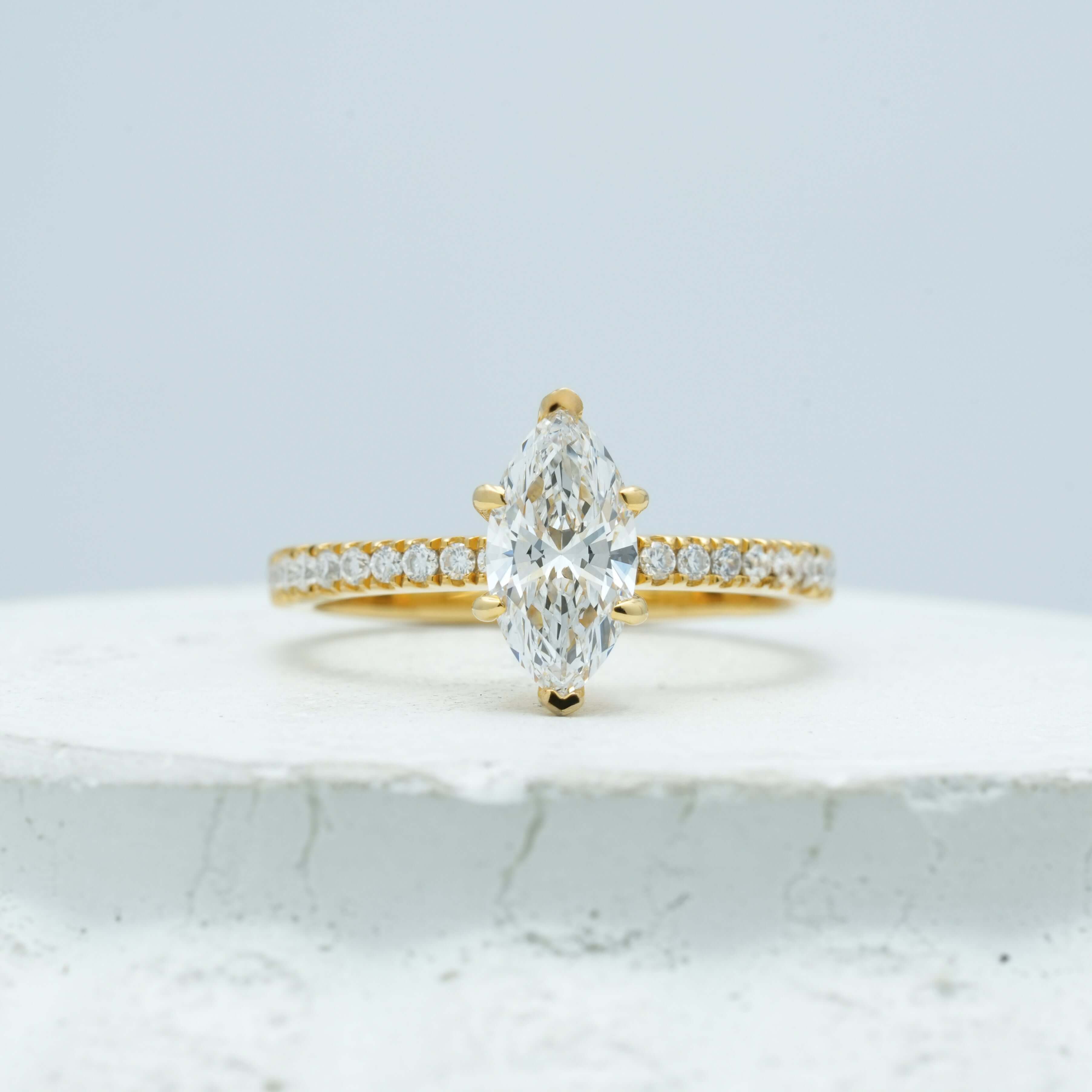 Detailed view of a marquise-cut diamond ring, highlighting the secure mounting and seamless pavé band design