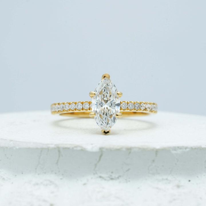 Detailed view of a marquise-cut diamond ring, highlighting the secure mounting and seamless pavé band design