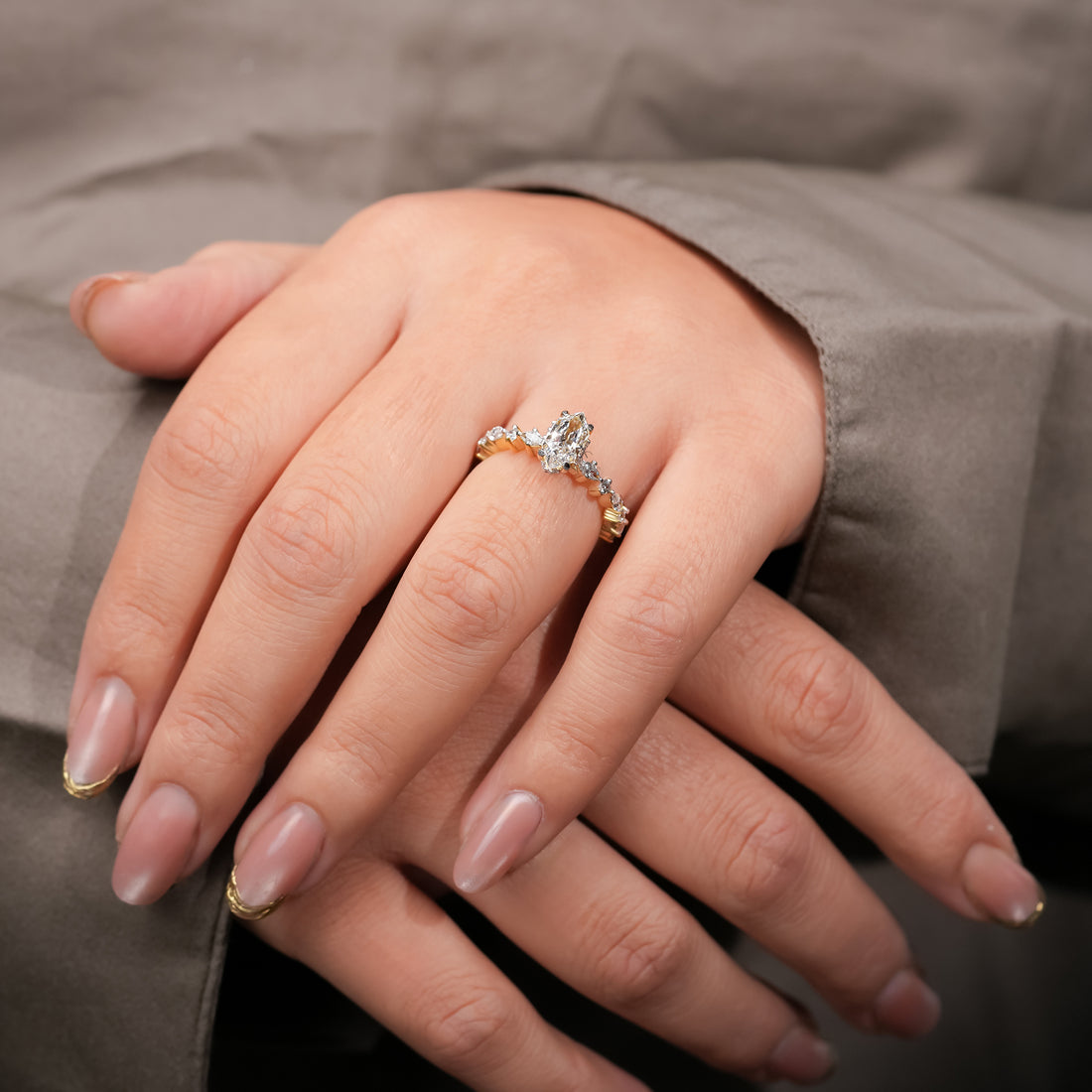 A graceful gold ring showcasing a marquise-cut diamond at its heart, complemented by alternating marquise and round accent diamonds along a delicate band, symbolizing eternal love and harmony.