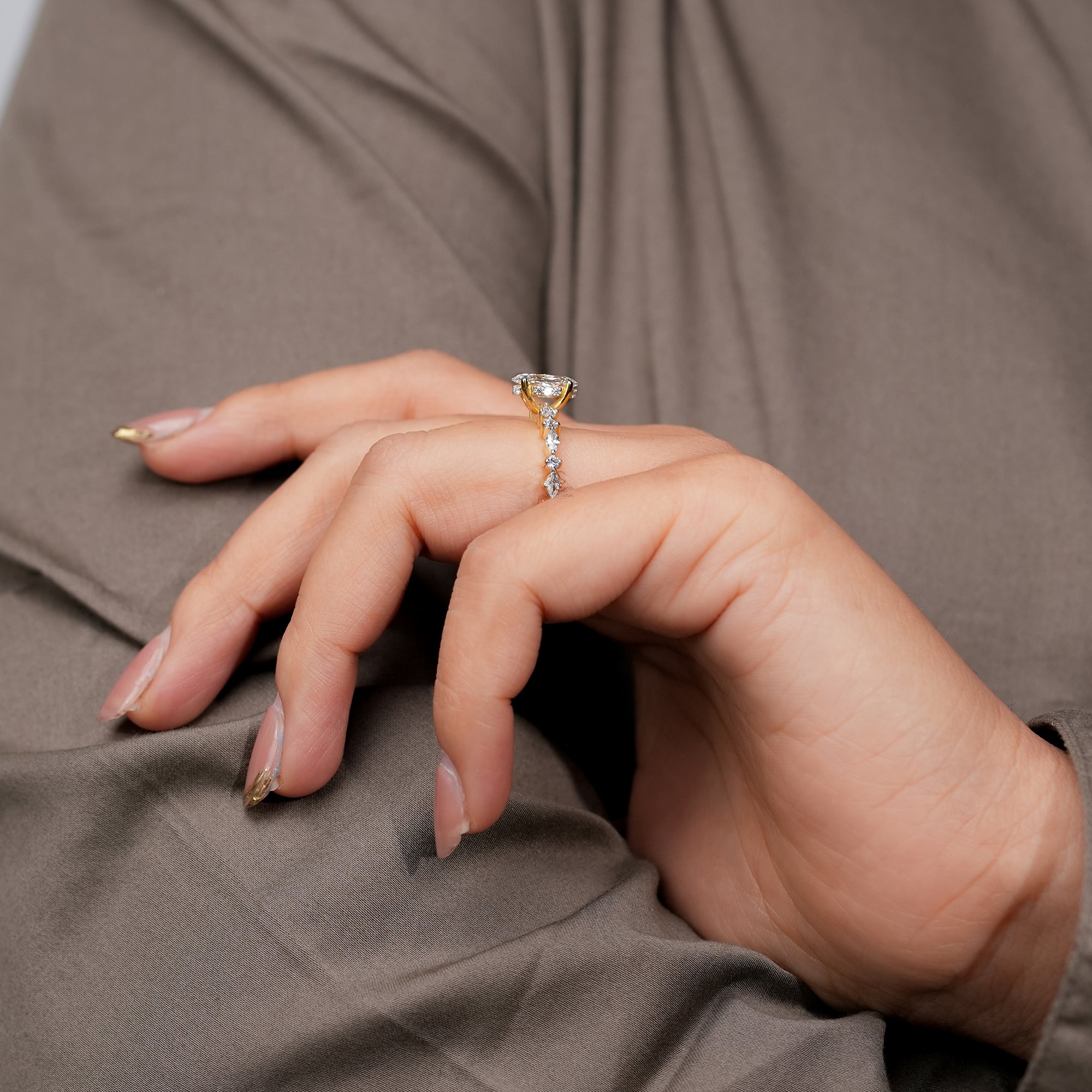 Gold marquise diamond engagement ring with alternating marquise and round accent stones on a detailed band a modern yet timeless design full of brilliance.