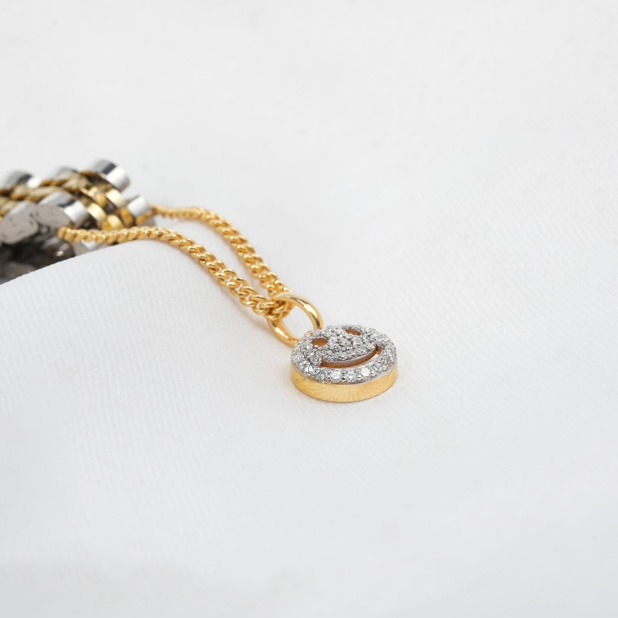 A gleaming silver-and-gold watch accented with a gold chain and a diamond smiley pendant, adding a touch of joy and sparkle to a timeless accessory.