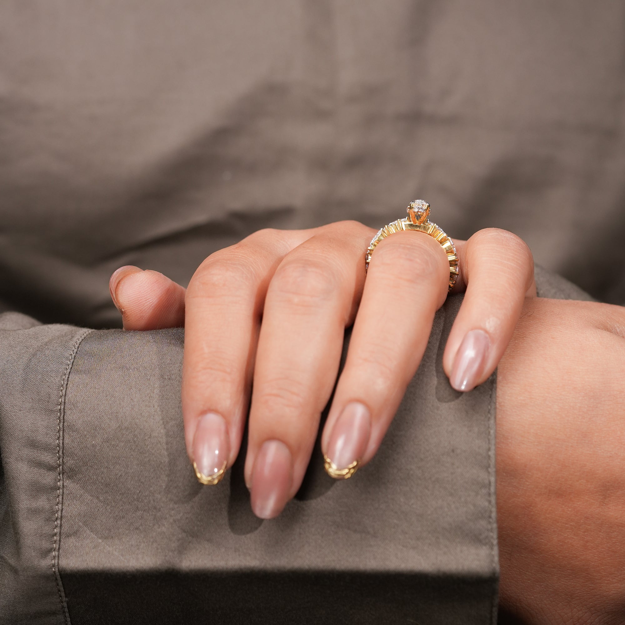An exquisite marquise diamond engagement ring set in polished yellow gold, enhanced by a sequence of alternating accent diamonds that reflect exceptional craftsmanship and radiance.