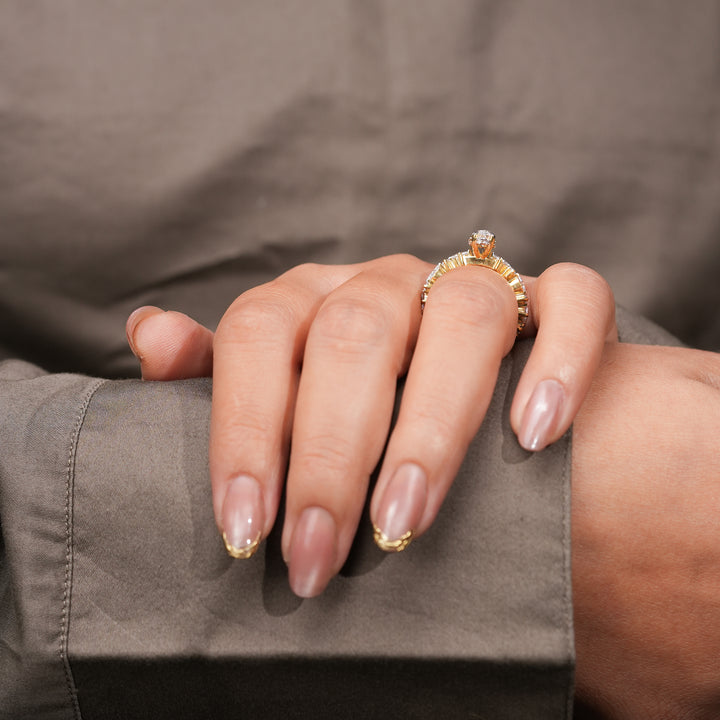 An exquisite marquise diamond engagement ring set in polished yellow gold, enhanced by a sequence of alternating accent diamonds that reflect exceptional craftsmanship and radiance.