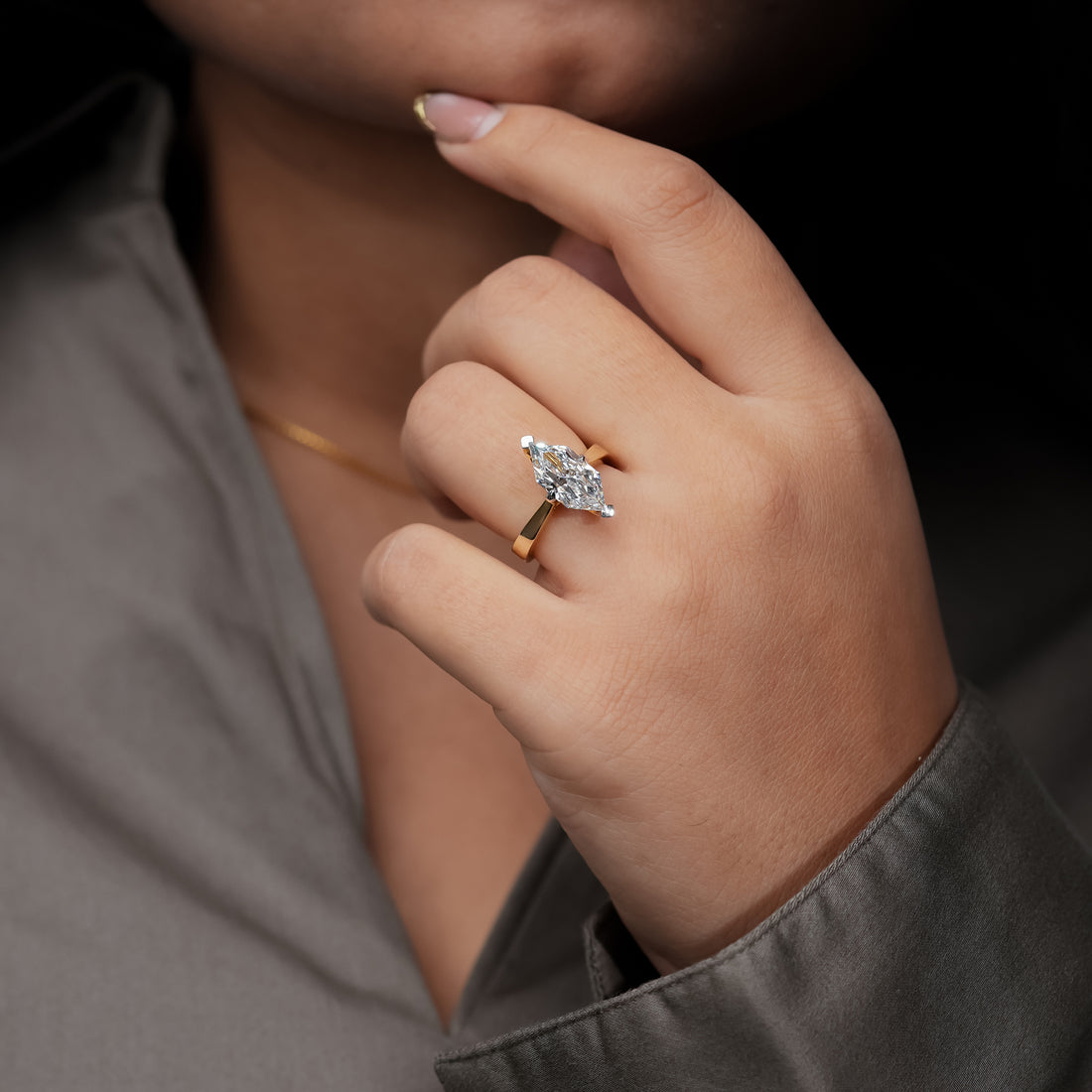 Gold marquise diamond engagement ring with a minimalist solitaire setting, featuring a brilliant marquise-cut diamond on a polished yellow gold band.