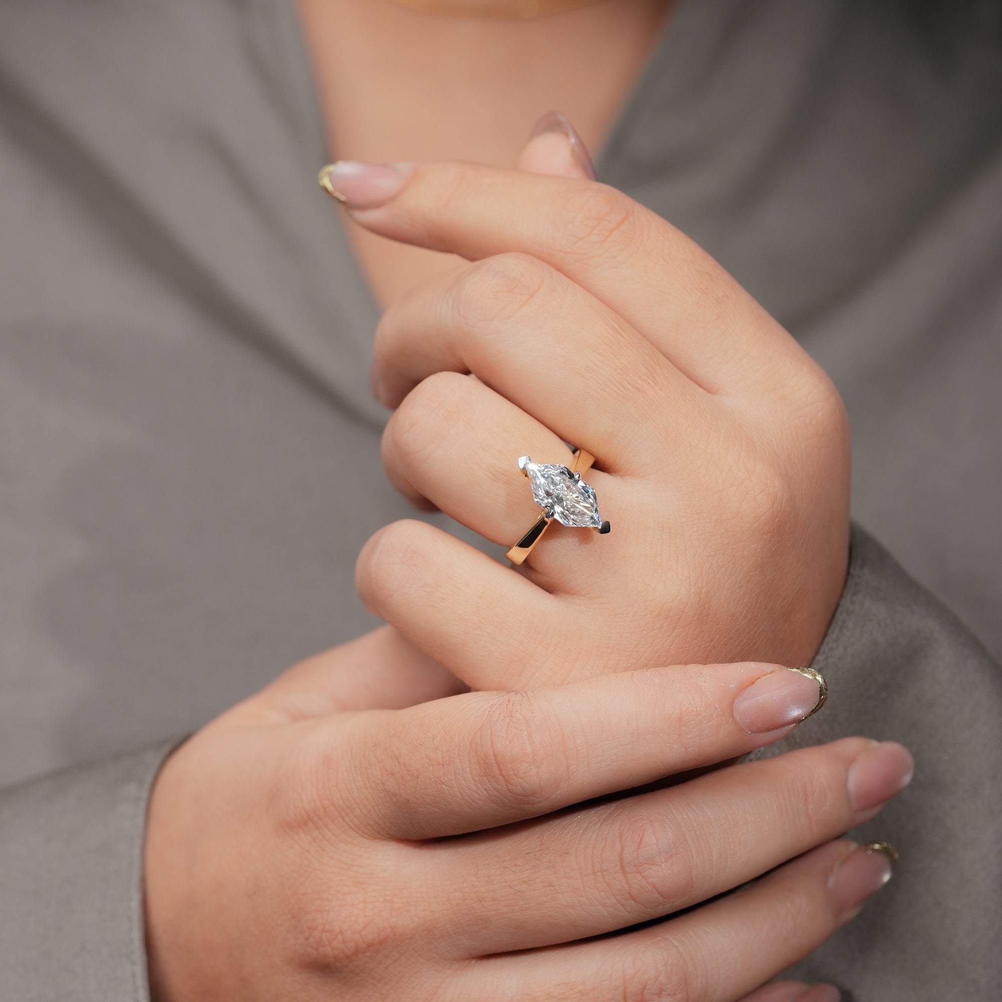 A graceful marquise diamond set on a lustrous gold band, radiating timeless elegance and symbolizing enduring love.